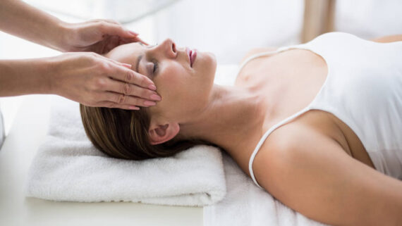 Masseur massaging woman at spa
