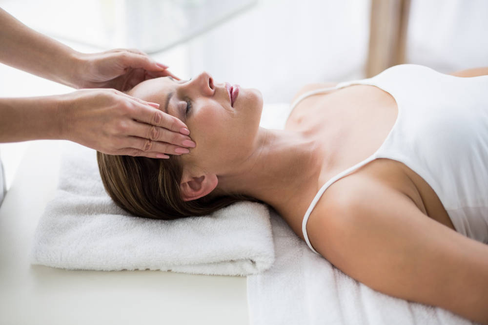 Masseur massaging woman at spa